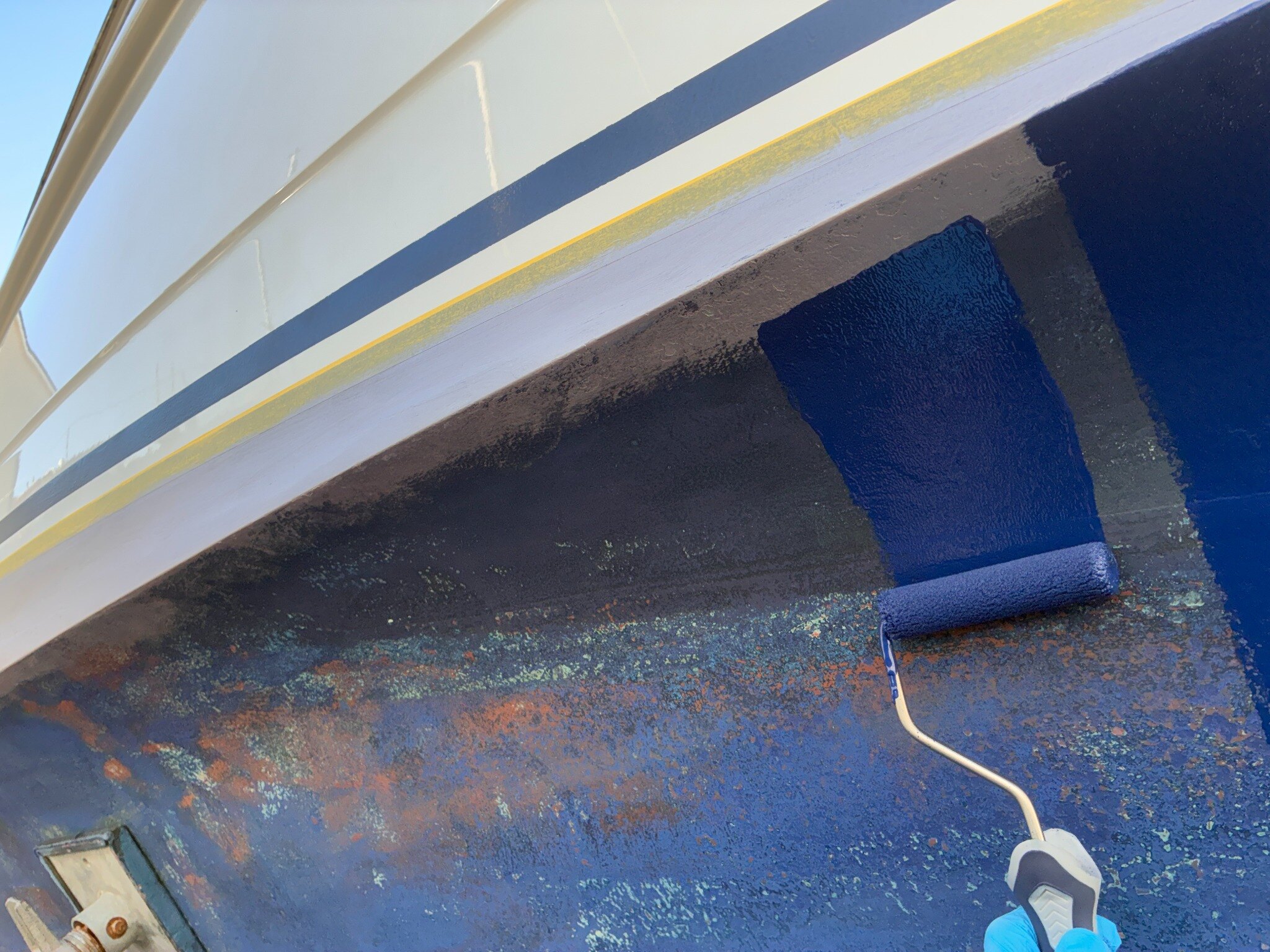 Fresh antifoul being applied carefully to a boat hull